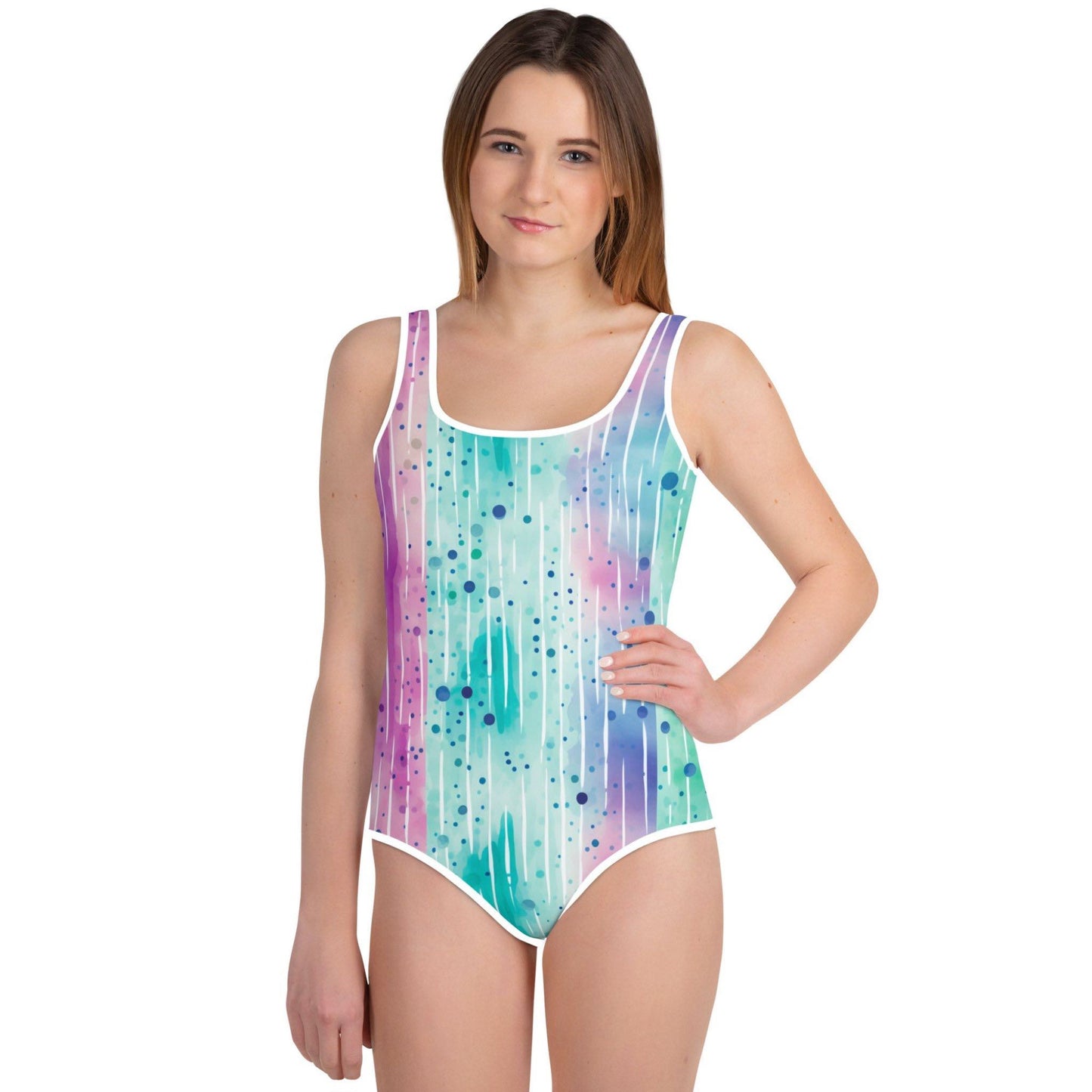 Youth swimsuit (one piece) with an abstract watercolour design depicting blue water ripples, worn by a teenage girl. White background.