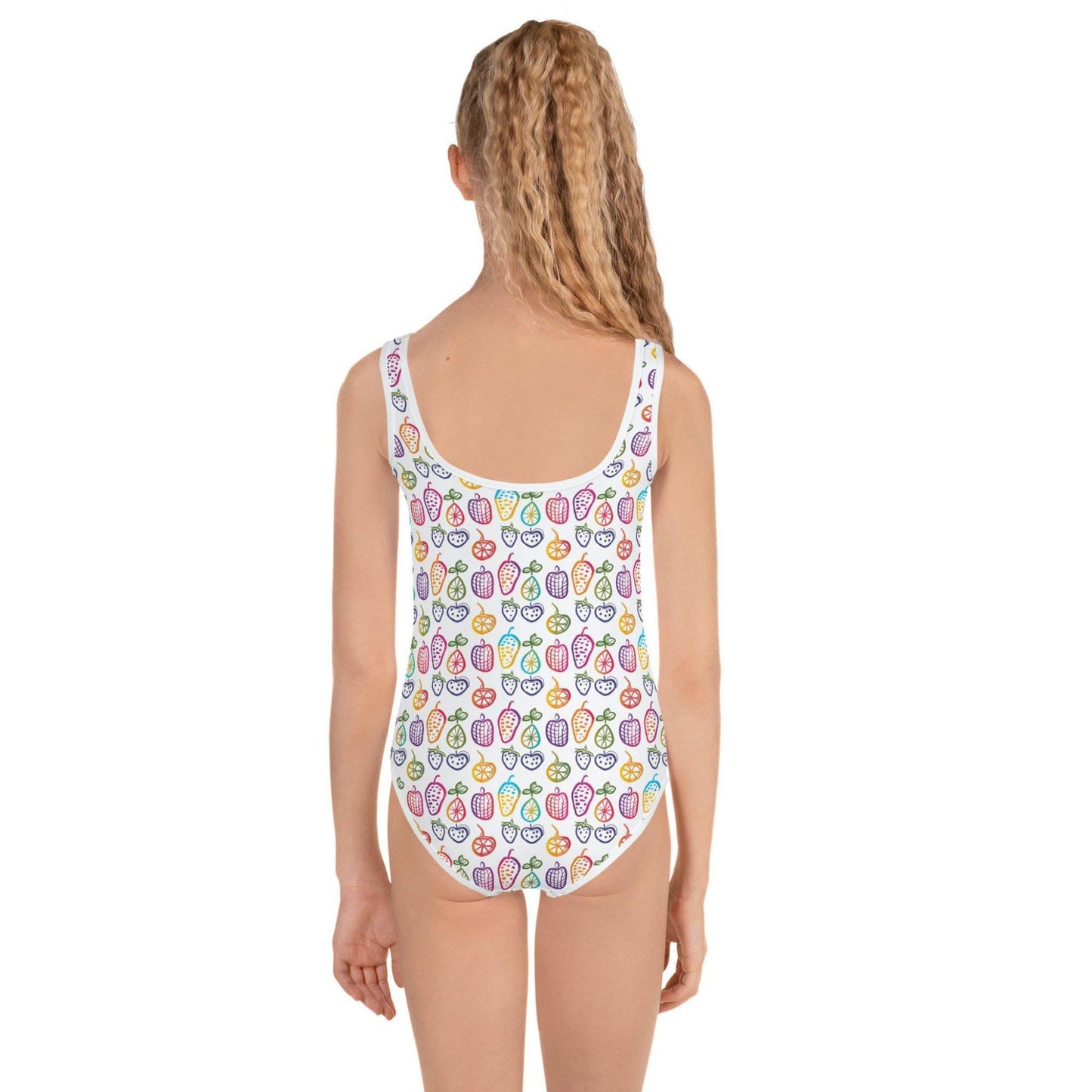Cute 1 Piece Swimsuits Juniors featuring a cheerful pattern of colorful fruit doodles across a pristine white background, worn by a young girl, her back facing the camera. White background.