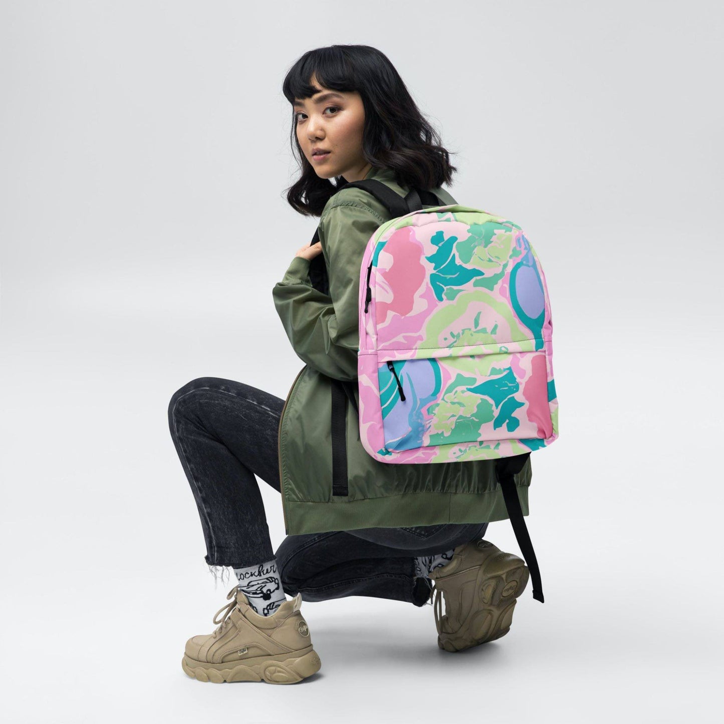 A pink floral backpack on the back of a girl.