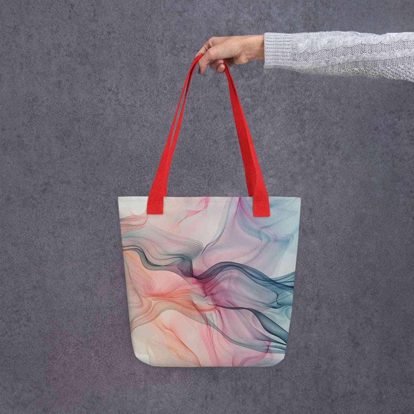Fashion ladies tote bag with red handles, which design features an abstract art of artistic wavy bluish and pastel lines, held by a lady's hand. Dimension 15x15 inches. Grey background.