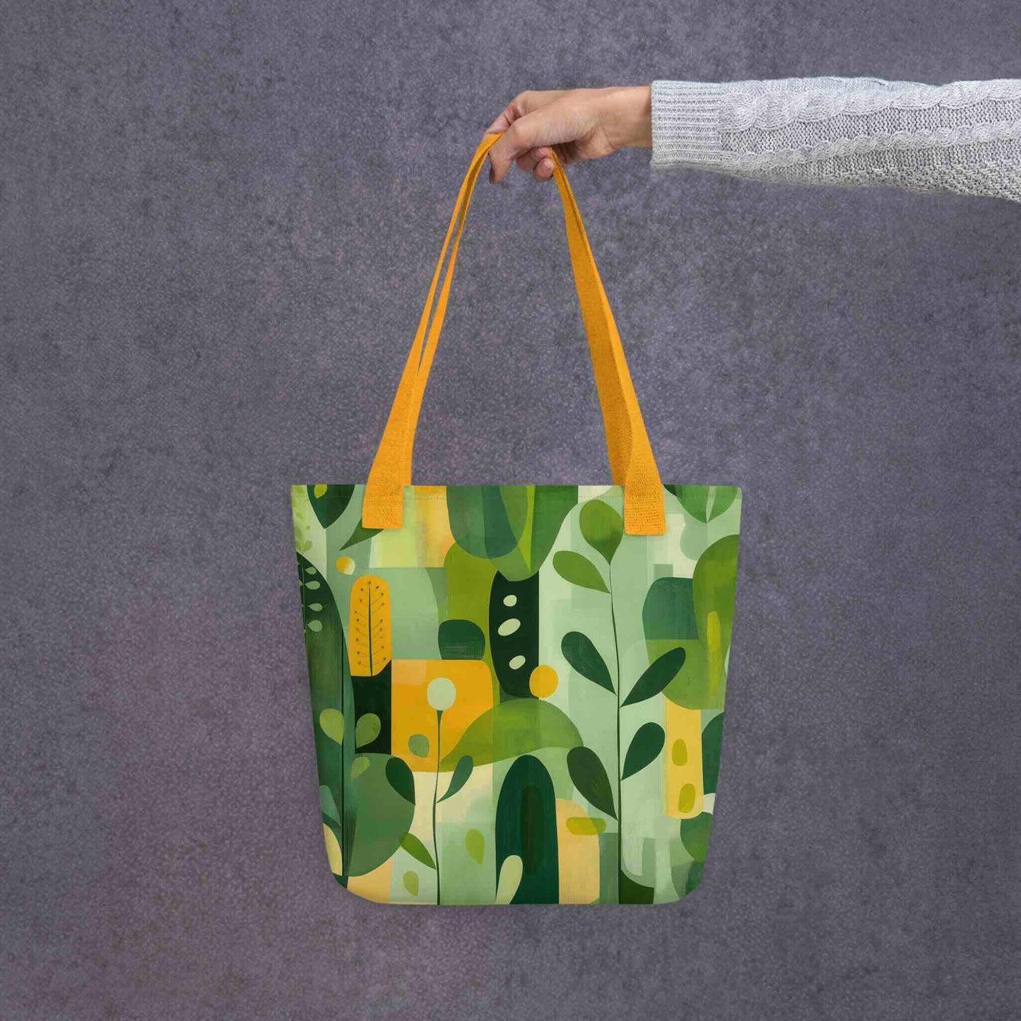 Carry nature's beauty with our "VERDURE" abstract tote bag. This spacious 15x15 inch canvas features soothing earth tones and organic shapes, a modern celebration of the natural world. Shop our unique abstract tote bags today and add a touch of calm sophistication to your style. Yellow handle. Grey background.
