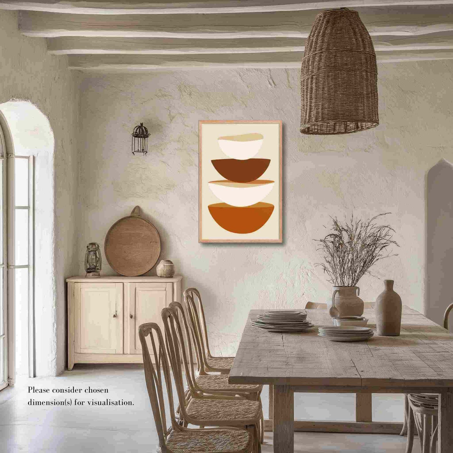 A minimalist abstract art form in framed poster, featuring stacked bowls in warm earthy tones on soft biege, its clean, contemporary, and slightly rustic aesthetic adds a touch of calm sophistication to your kitchen or dining area. Framed in wood in red oak color. The poster hangs on a textured biege wall in a dining area in a rustic country setting.