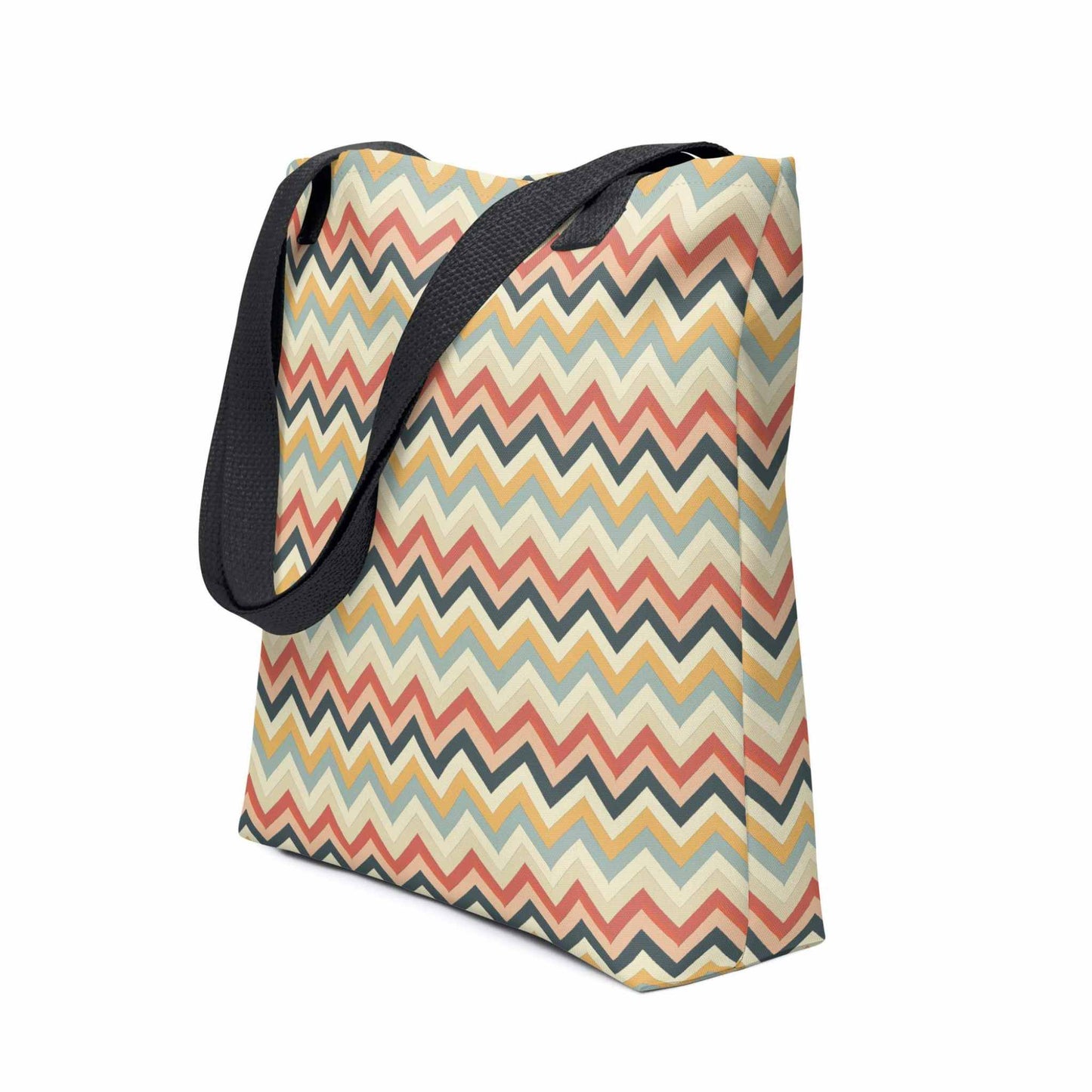 Zig zag tote bag with black handles, in a multicoloured pattern of Zig Zag lines, shown in side view. Dimension 15x15 inches. White background.