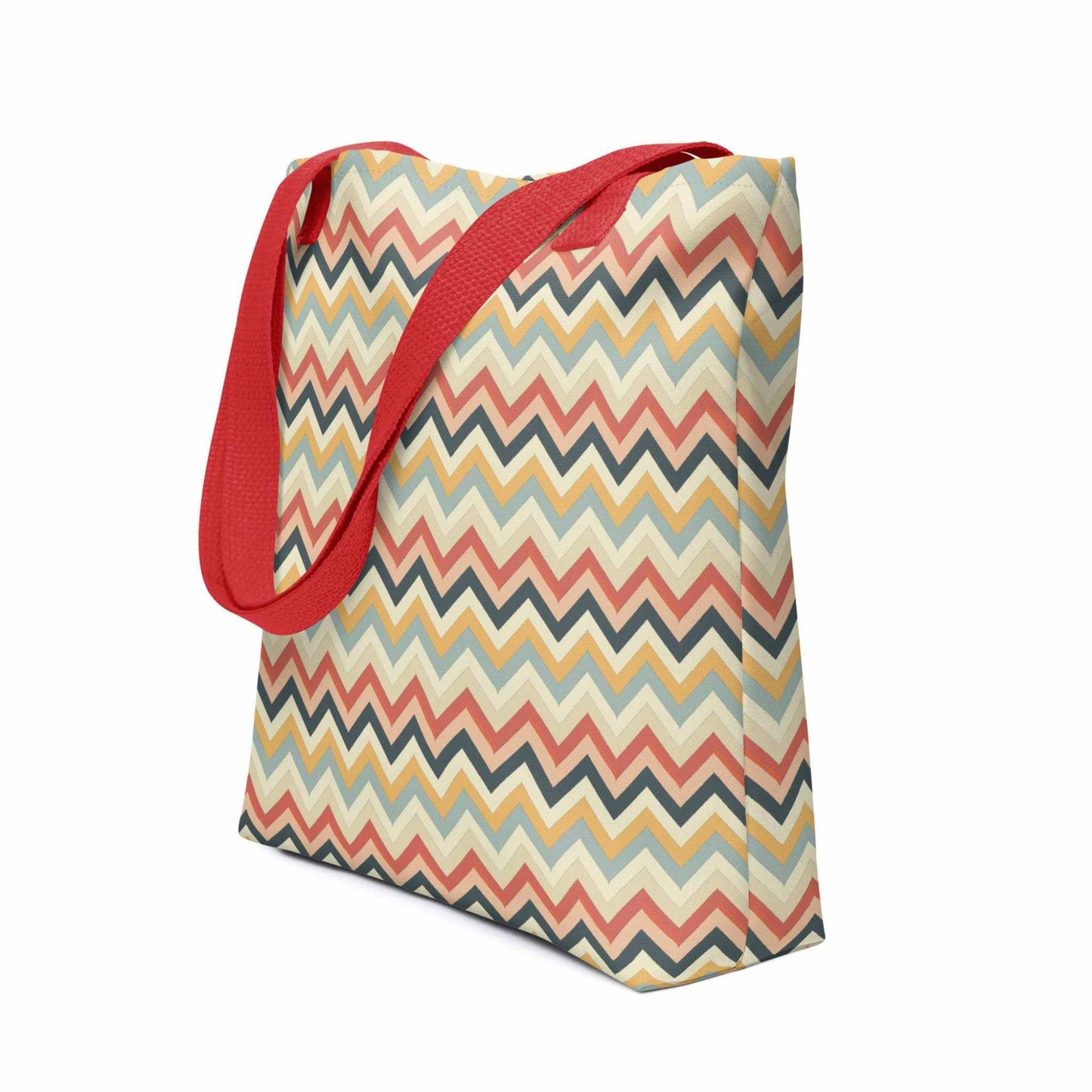 Zig zag tote bag with red handles, in a multicoloured pattern of Zig Zag lines, shown in side view. Dimension 15x15 inches. White background.