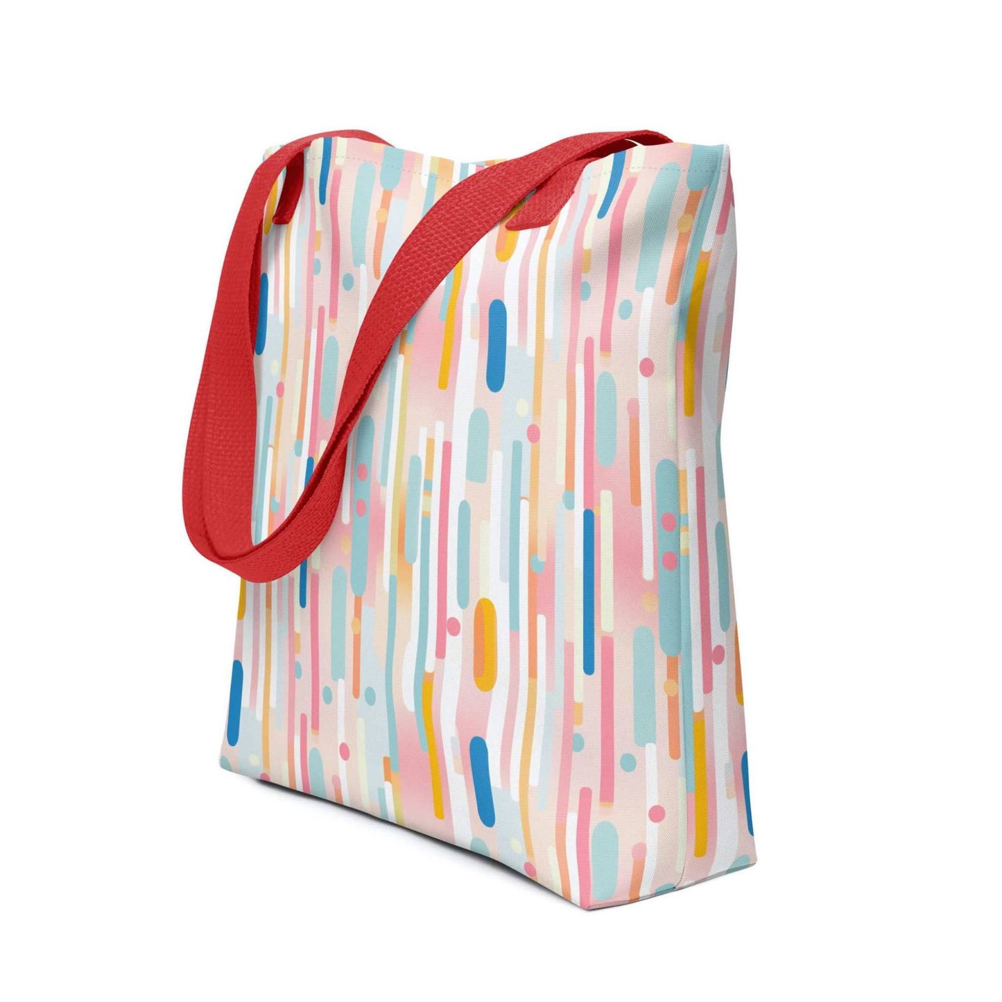 Light pink tote bag with red handles, which design is abstract vertical lines of pastel pink and other pastel shades, shown in side view. Dimension 15x15 inches. White background.