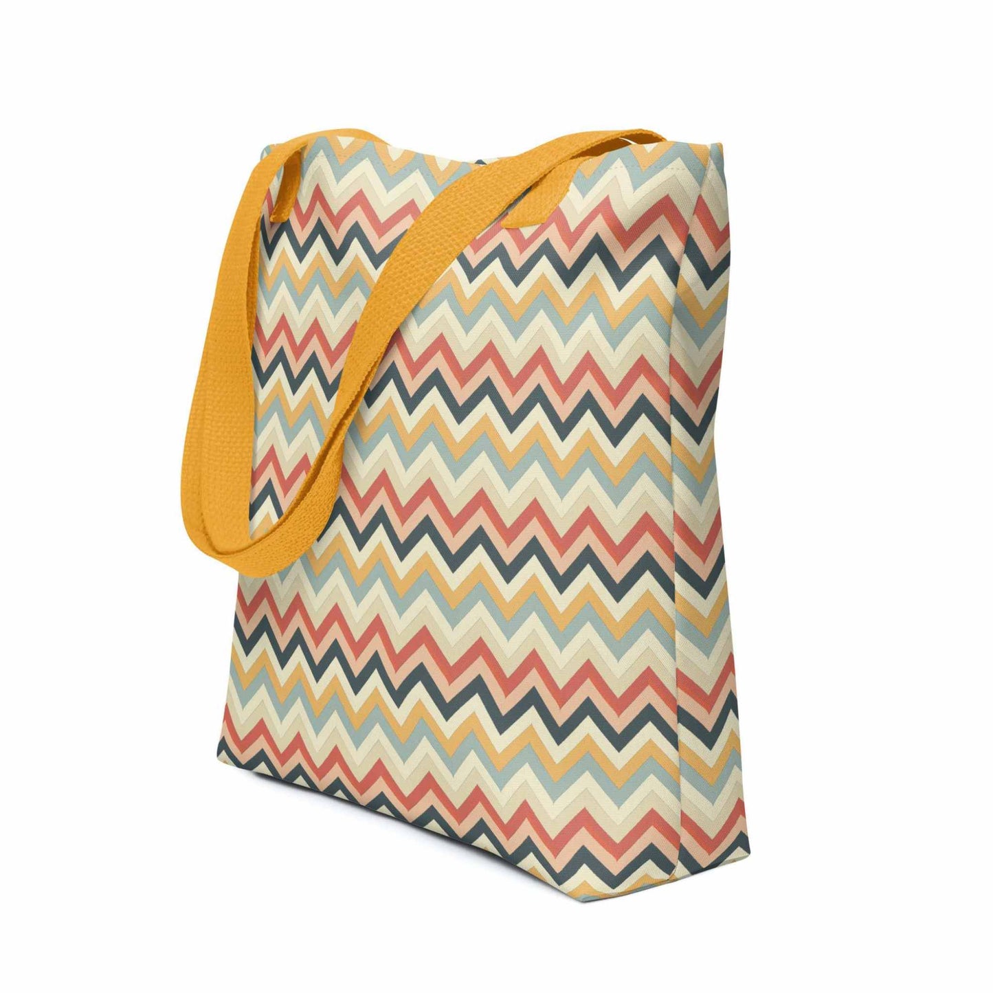 Zig zag tote bag with yellow handles, in a multicoloured pattern of Zig Zag lines, shown in side view. Dimension 15x15 inches. White background.