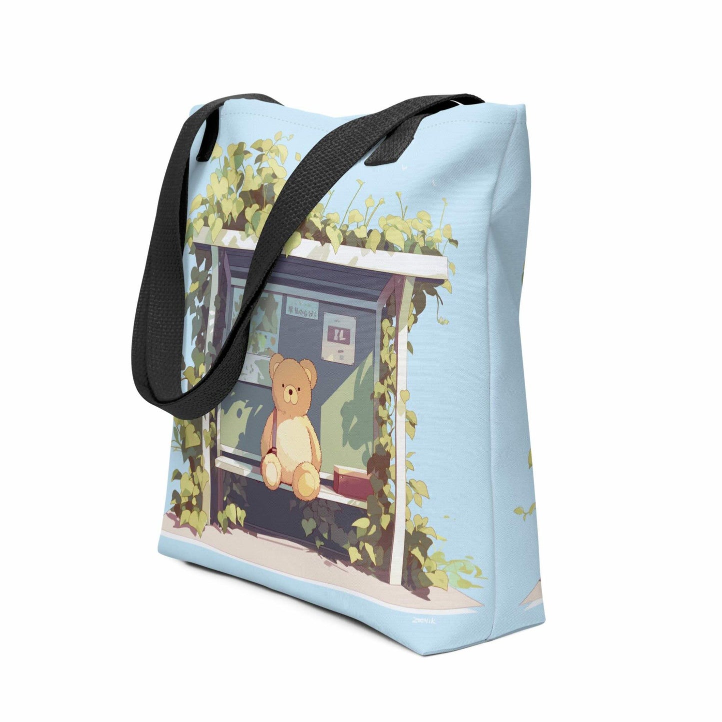 Teddy Bear Tote Bag which features a cute teddy bear waiting sweetly at the bus-stop, in a charming, tranquil setting in nature, with green and mint tulip colors. Black handles. Dimension 15x15 inch polyester. Side view. White background.