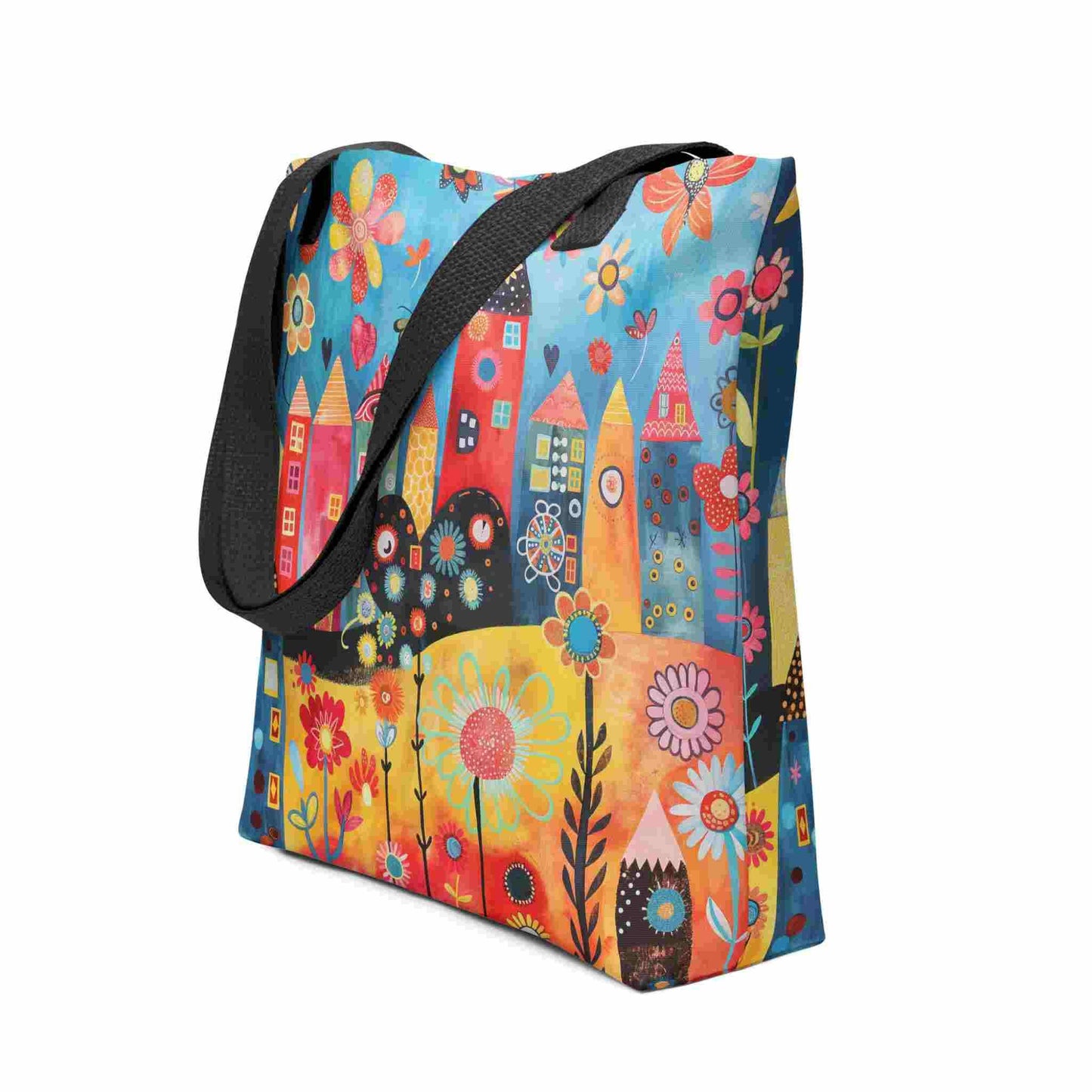 A ophisticated whimsical tote bag which brings vibrant folk art houses and flowers to life, with black handle. 15x15 inch. Side view. White background.