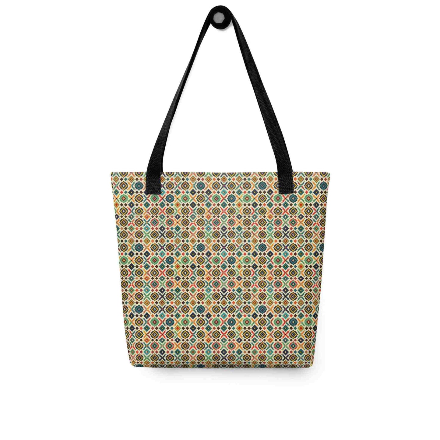 A 15x15 inch tote bag with black handles, which design is an Argentine inspired diamond pattern, hanging on a wall. White background.