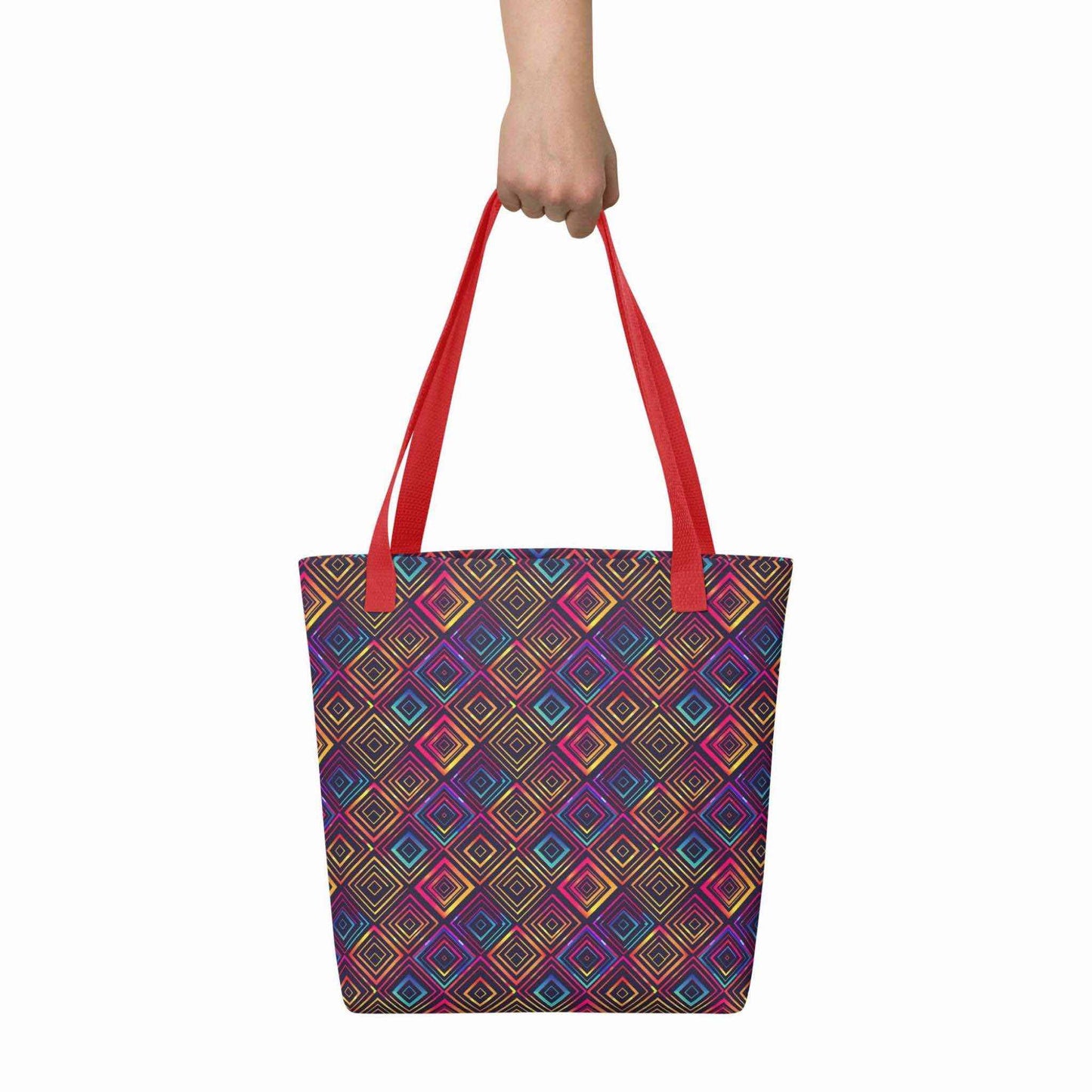 Fashion tote bag with red handles, which features a neon tapestry design in a sophisticated blend of colors, held in a hand. Dimension 15x15 inches. White background.