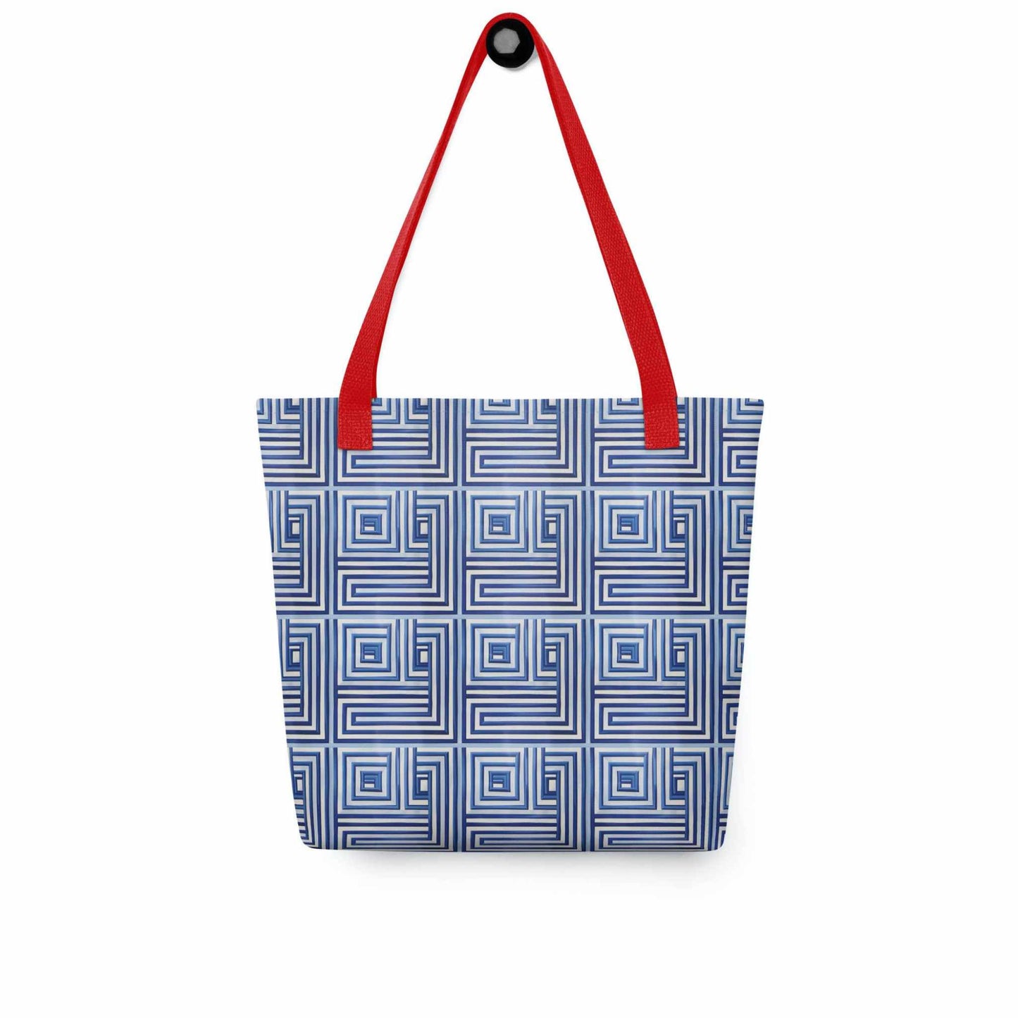 Blue op art tote with red handles, which features a blue op art illusion, hanging on a white wall.