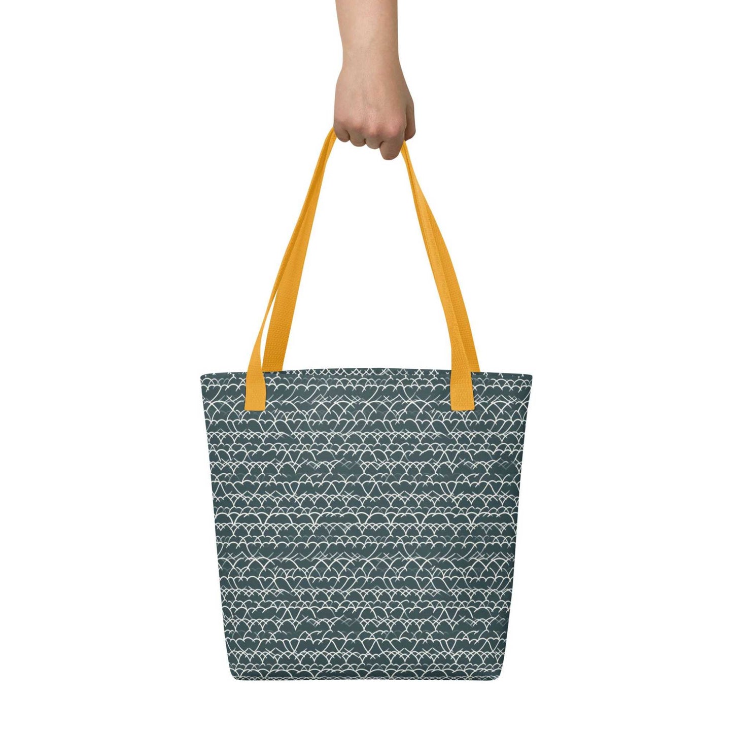 Blue Tote with White Geometric Lace with yellow handles. held bin a hand against a white wall. Dimension 15x15 inches.