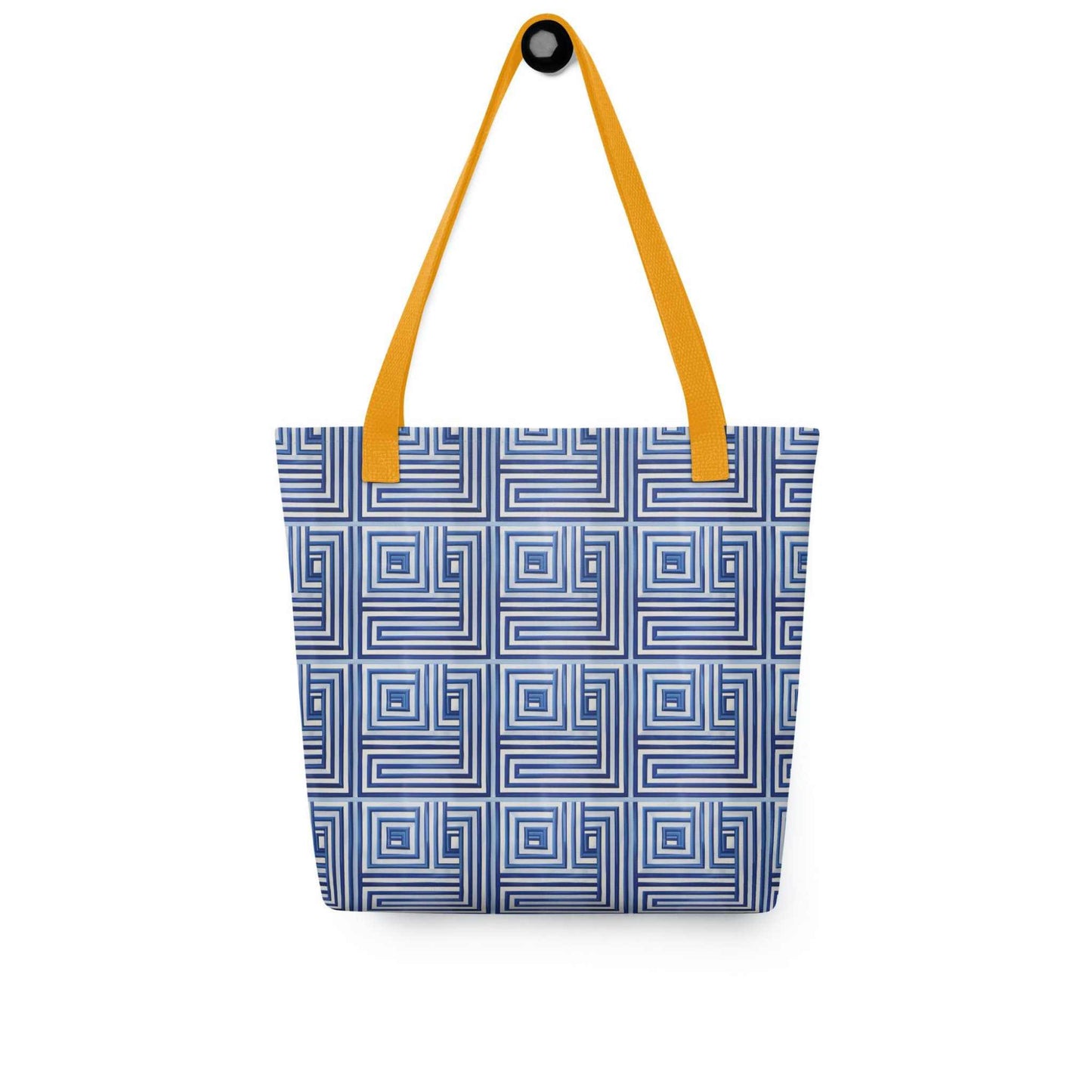 Blue op art tote with yellow handles, which features a blue op art illusion, hanging on a white wall.