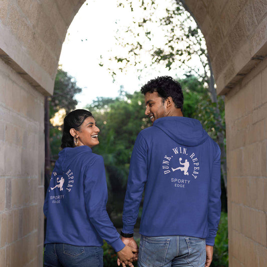 ack view of man and woman holding hands wearing matching team royal cotton basketball hoodies under an arch.