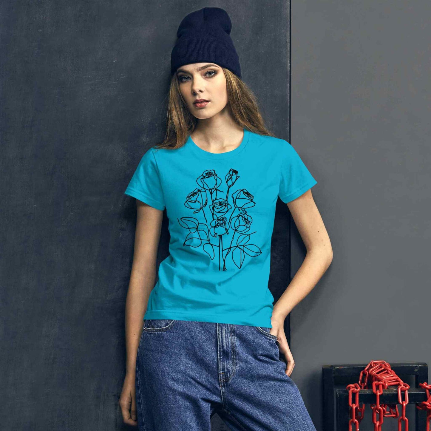 A trendy woman in a caribbean blue fashion fit short sleeve cotton t-shirt with an elegant pencil sketch of a bouquet of roses.