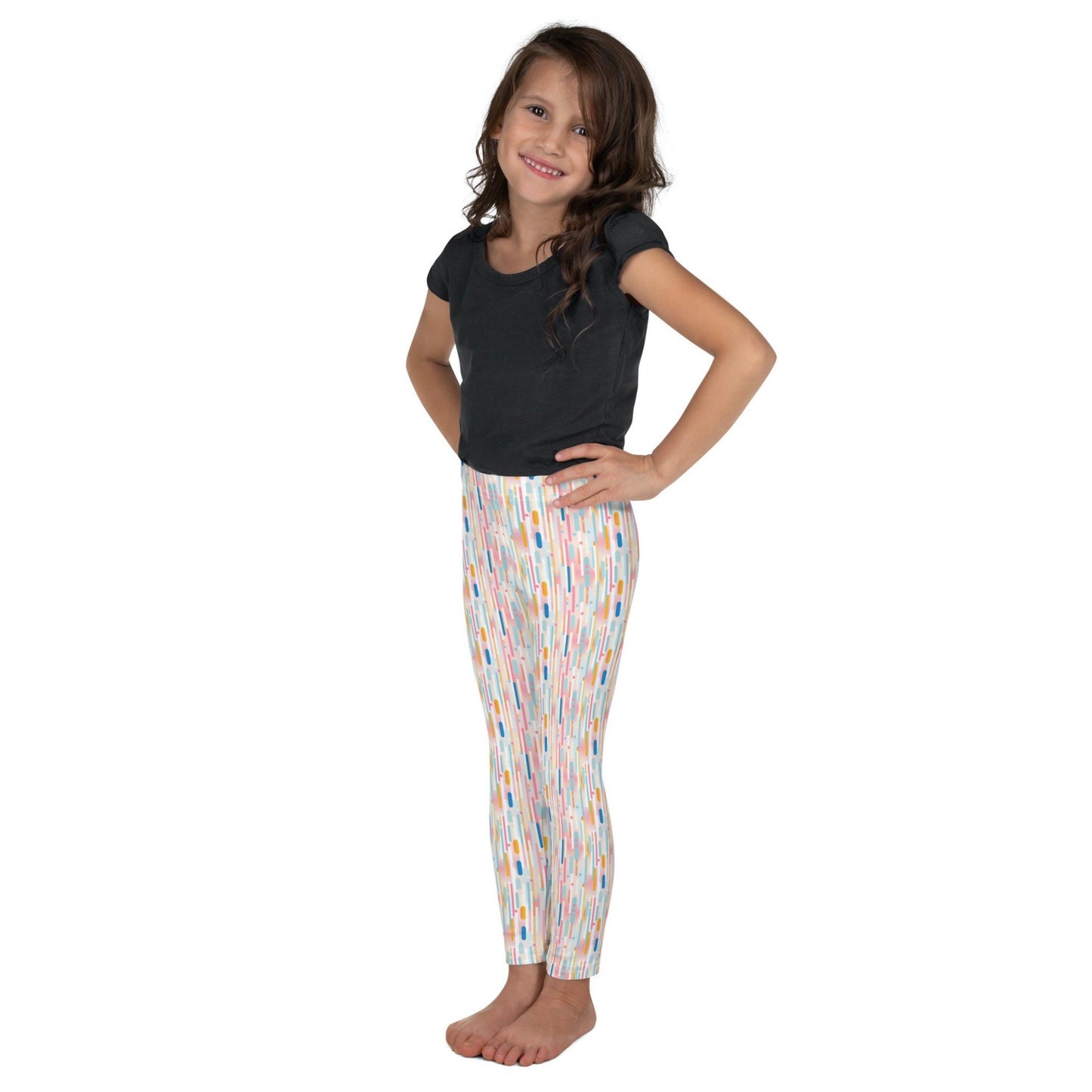 Kid and roddler leggings which features playful candy colored lines in a white background, worn by a little girl. TWhite background.