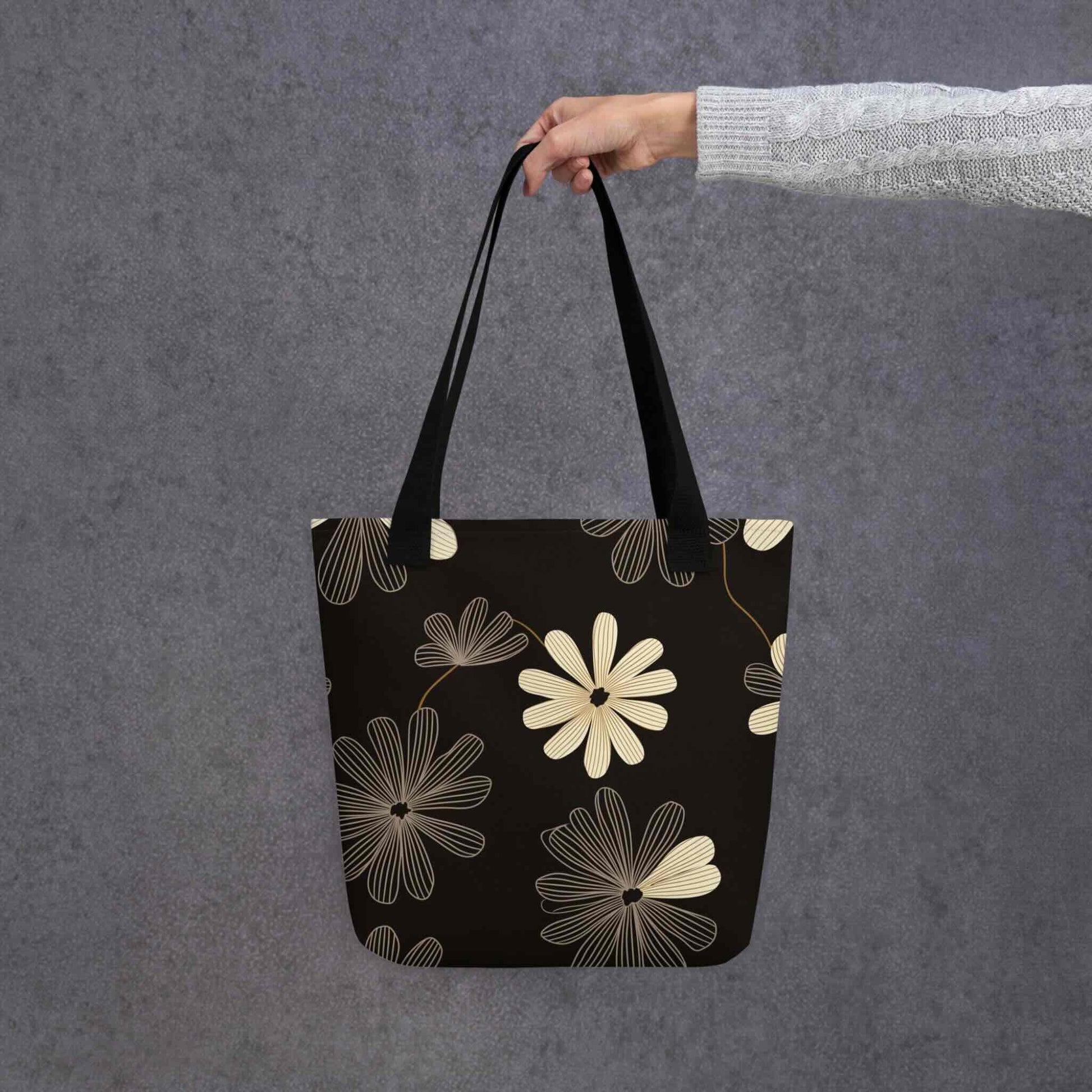 Aesthetic Tote Bag which features striking black and white line art flowers, blending Art Deco sophistication with modern minimalist style. The high-contrast, deep-hued pattern makes a dramatic statement. 15x15 inch polyester. Grey Background.