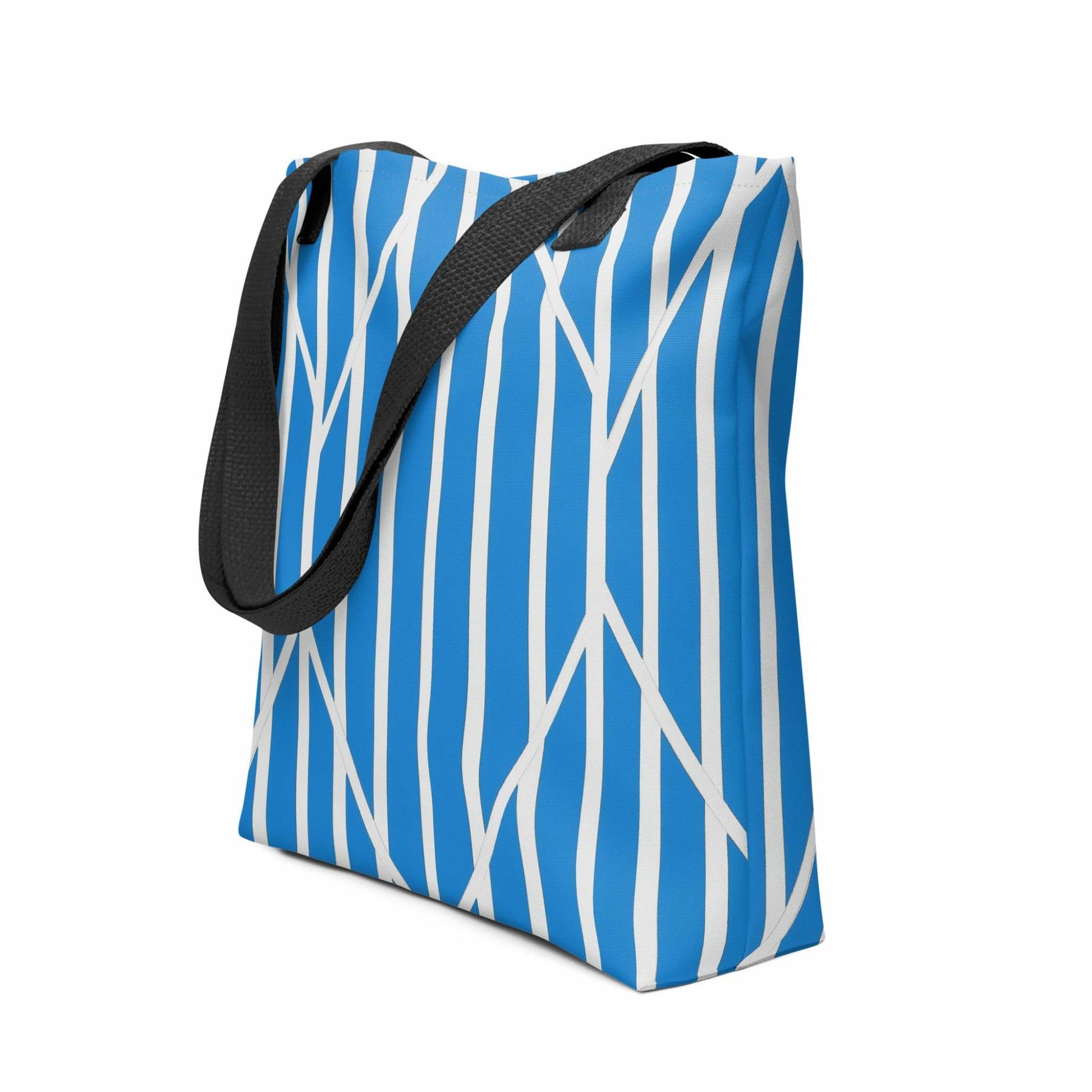 A tote bag with a striking design of blue and white striped tote which is a piece of kinetic art. The ordered rhythm of vertical stripes is dramatically intersected by bold, angular lines, creating a beautiful tension and dynamic focal point. Dimensions 15x15 inches. Side view. White background.  