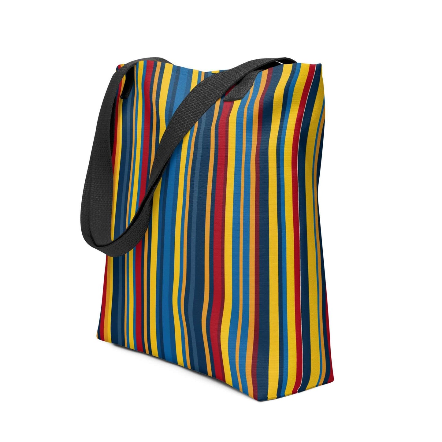 A blue striped tote bag which features a stunning geometric pattern in rich navy, glamorous gold, and deep burgundy, capturing the sophistication of high-end design, held in a hand. Black handles. Dimension 15x15 Inch polyester tote. Side view. White background.