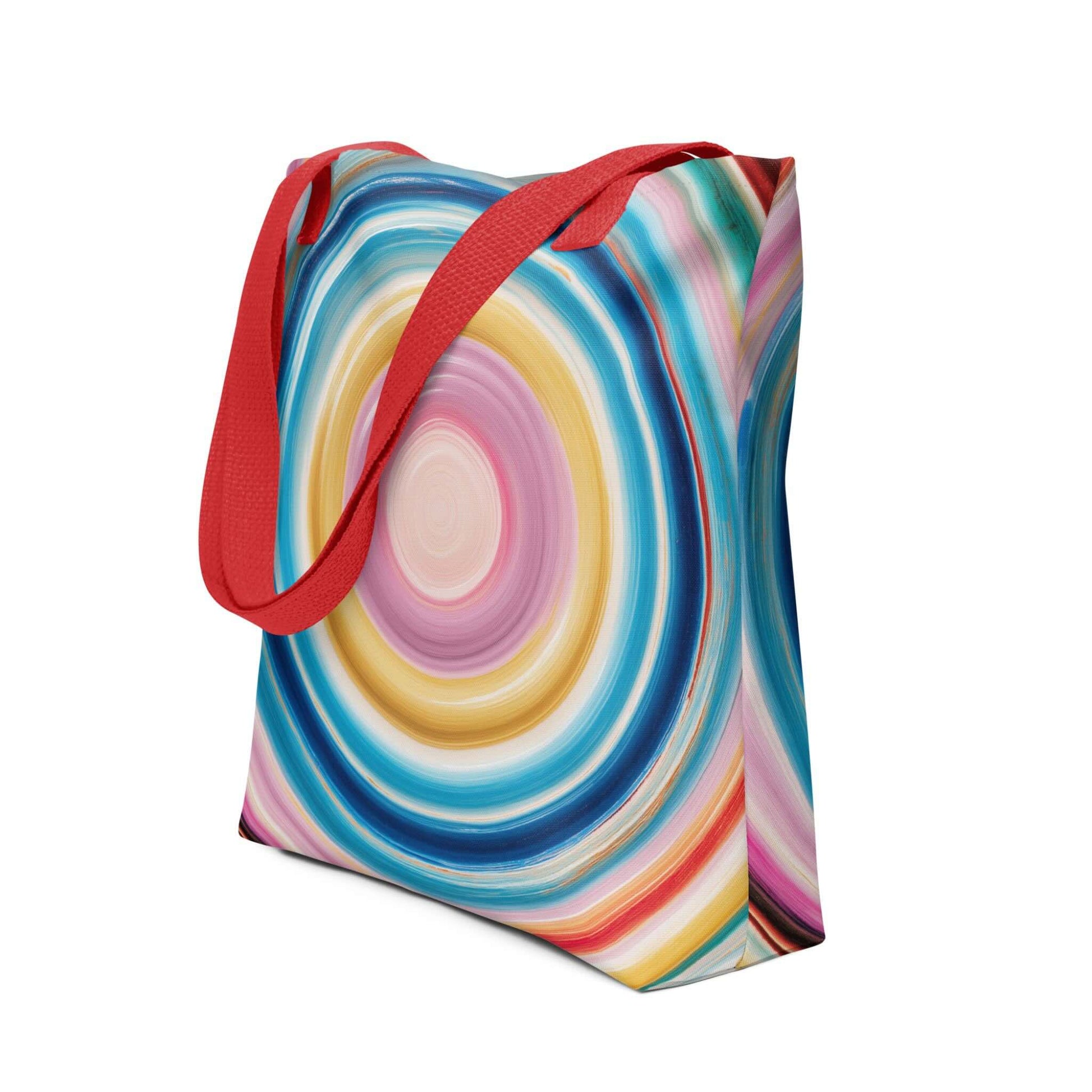 Colorful tote bag which features a mesmerizing abstract design of strong, hypnotic color circles, with red handles. Dimension 15x15 inches, polyester. Side view. White blackground. 