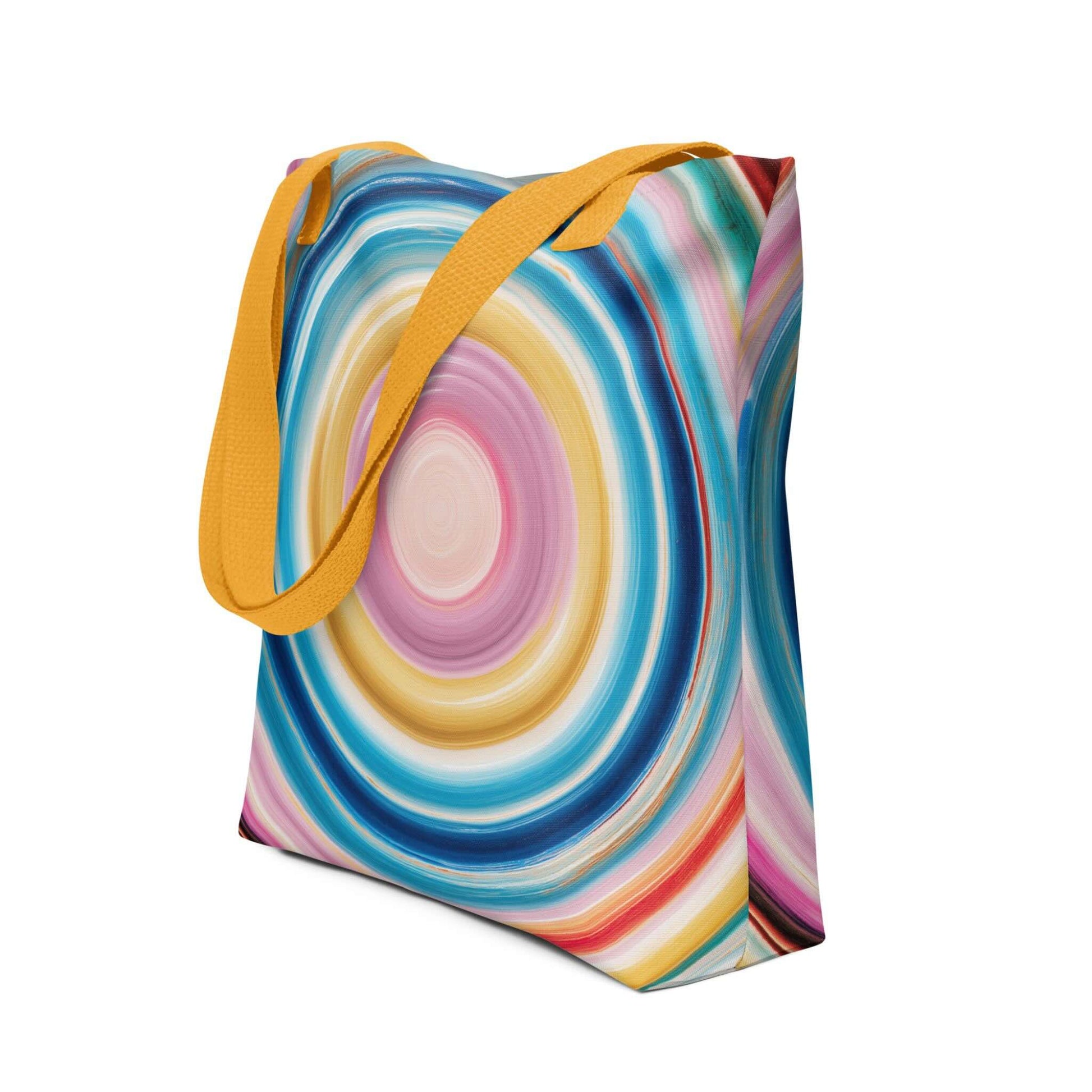 Colorful tote bag which features a mesmerizing abstract design of strong, hypnotic color circles, with yellow handles. Dimension 15x15 inches, polyester. Side view. White blackground. 