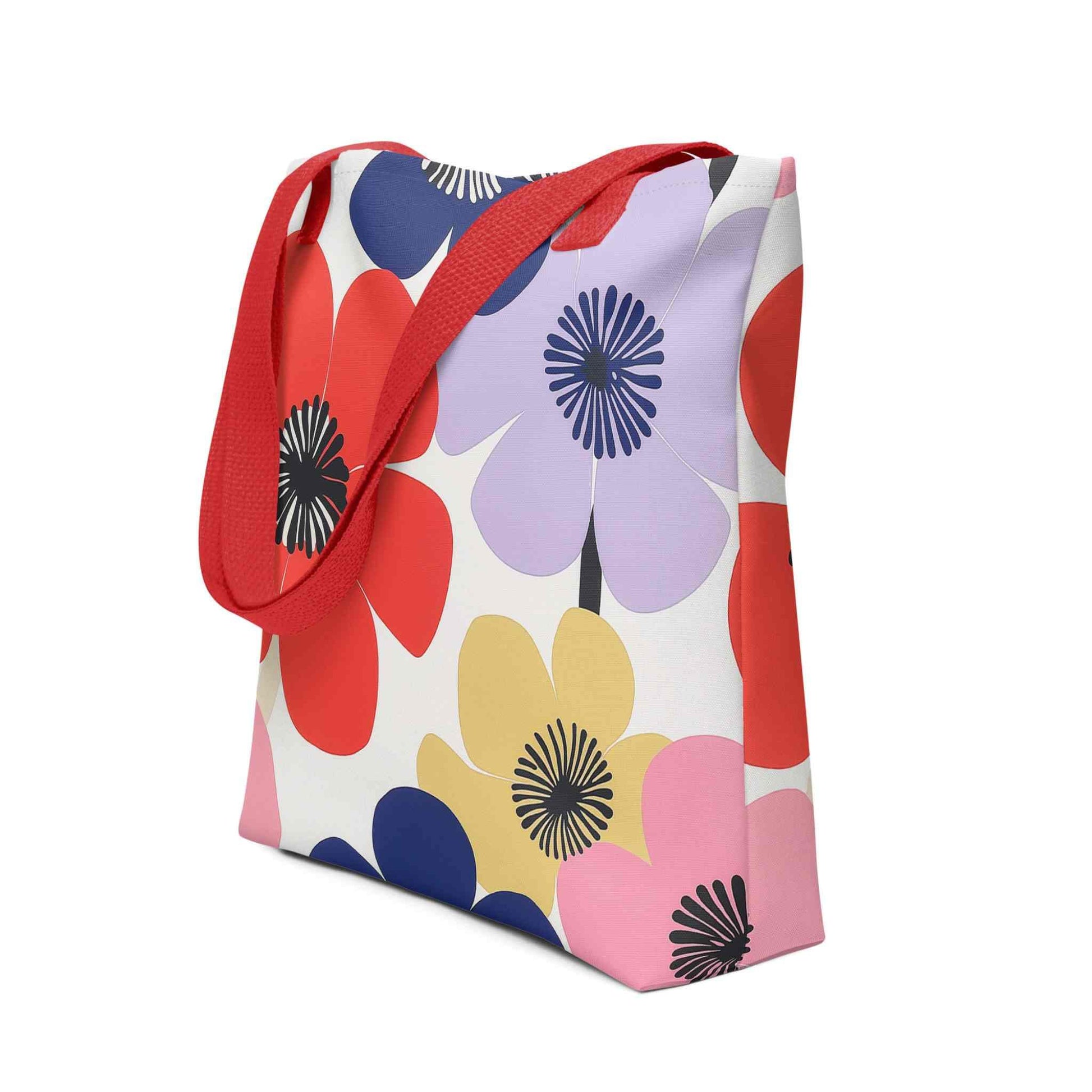 A Floral Tote Bag, with red handles, which features a stunning, abstract bloom pattern that brings warmth and joy wherever you go. Side View. White background.