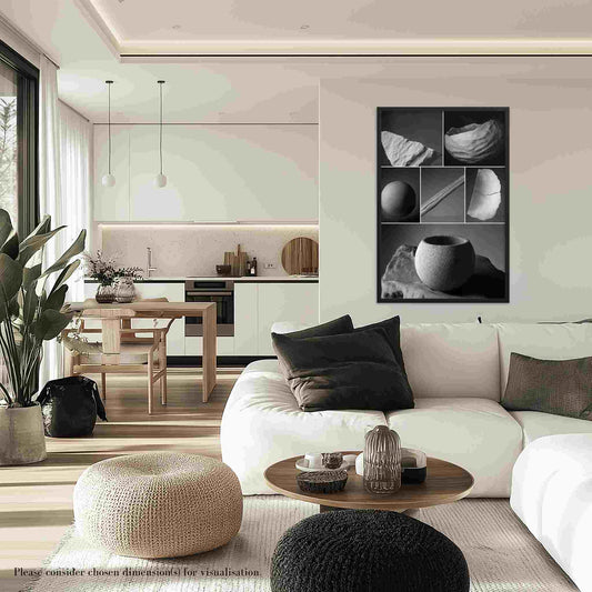 A black and white montage with a nature-inspired theme of natural elements, framed in elegant black,  mounted on a wall above a white sofa, featuring various natural elements like stones and plants.