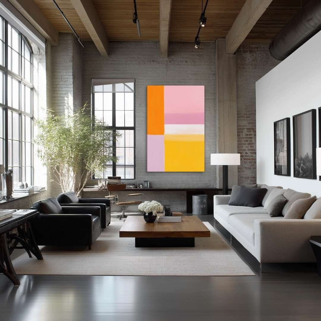 Illustration of Color Block Painting PALETTE. This stunning abstract canvas welcomes soft, radiant energy into your space. The artwork is a harmonious blend of energetic warm tones (sunny yellow and bright orange) with calming pastel colors (pink and mauve), and hangs in a modern grey and black living room.