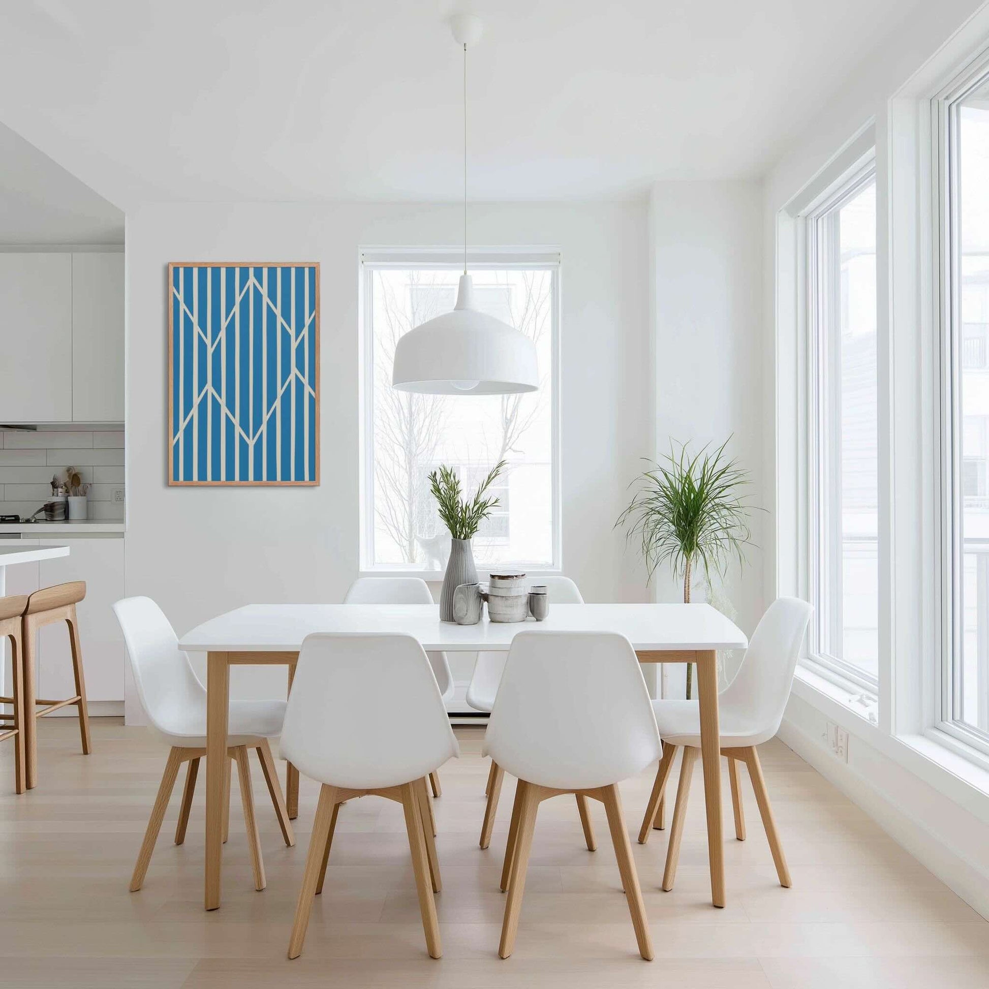 Illustration 4 of a compelling piece of blue and white abstract art, OBLIQUE, in framed poster. This sophisticated design creates visual drama as static vertical stripes are dynamically intersected by bold, angular white lines. The result is a striking, kinetic composition perfect for modern interiors. The framed poster hangs on white wall in a contemporary dining area.
