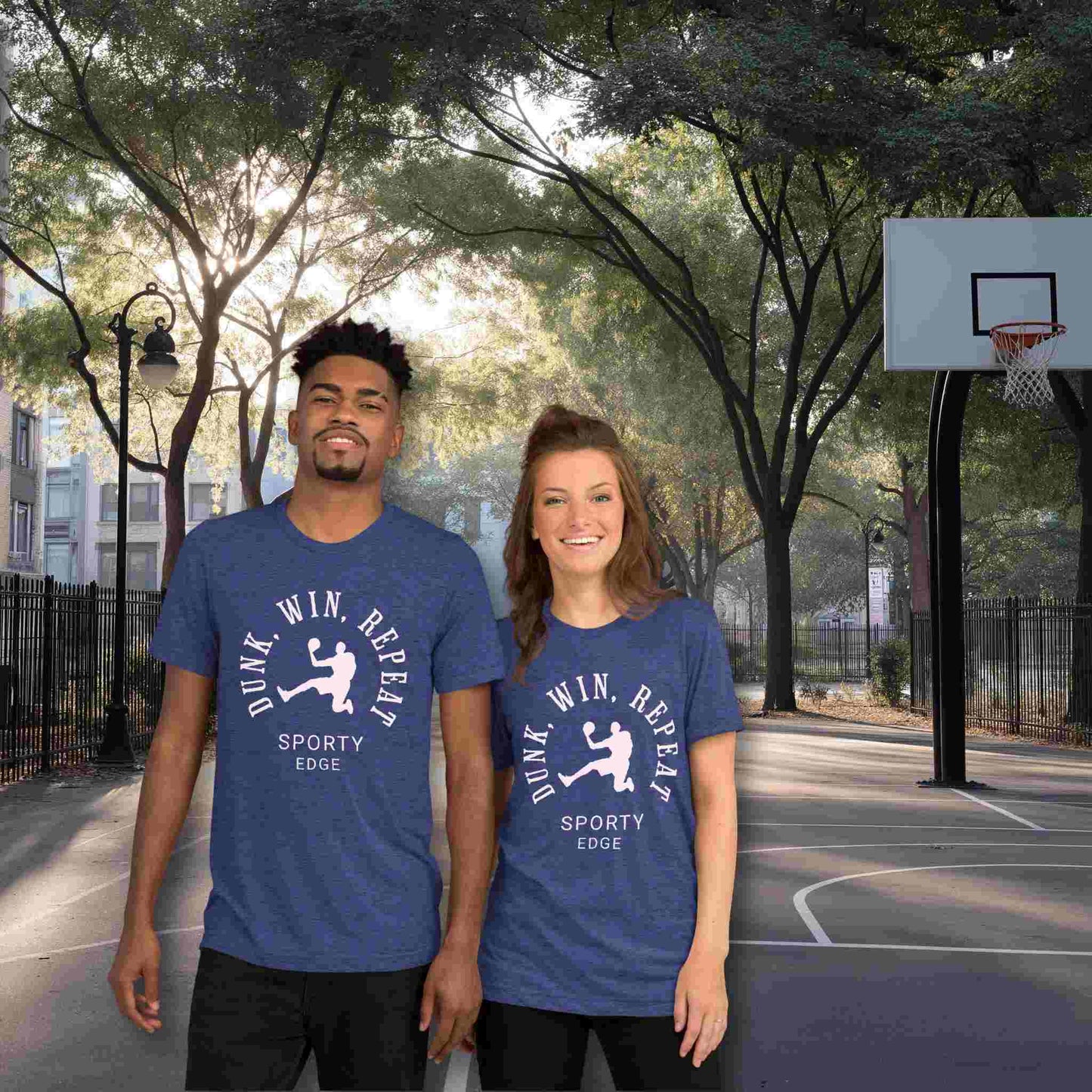 Basketball graphic tshirts in navy blue color won by a couple standing on a basketball court. The unisex triblend tshirt features the words "Dunk, Win, Repeat and Sporty Edge" circling a graphic of an active basketball player.