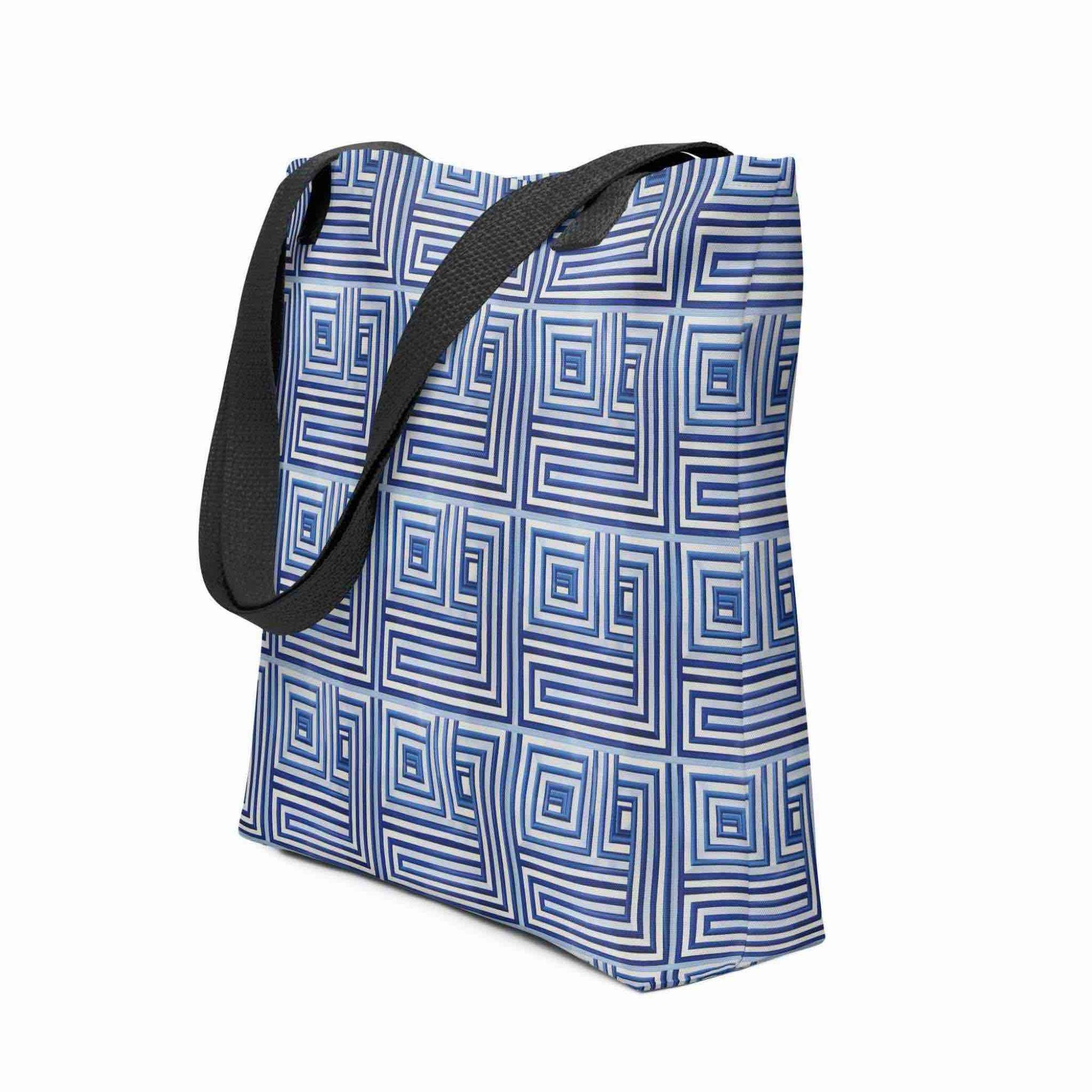 Side view of a 15x15 inch tote bag with black handles, which features a blue op art illusion on a white background. White background