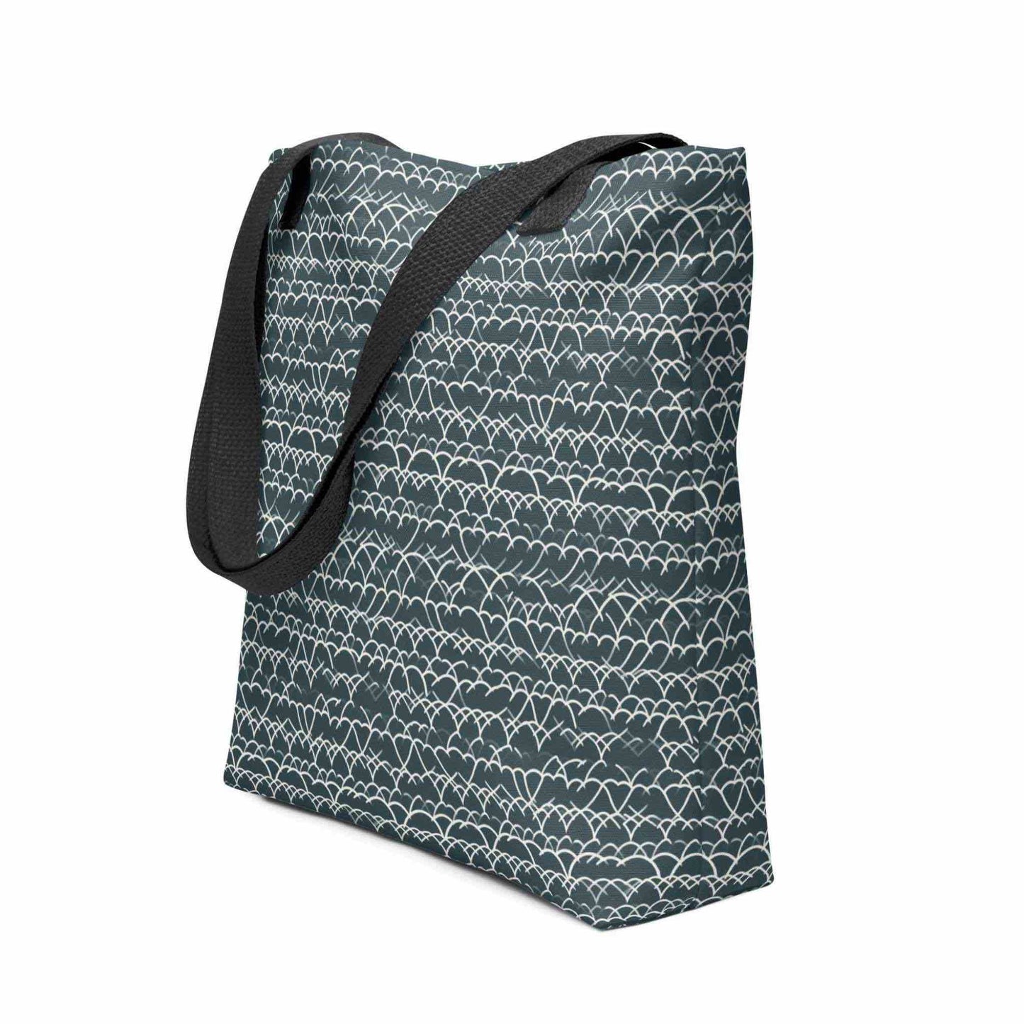 Side view of a 15x15 inch tote bag with black handles, which features a white geometric lace design that dances across a blue background. White background.