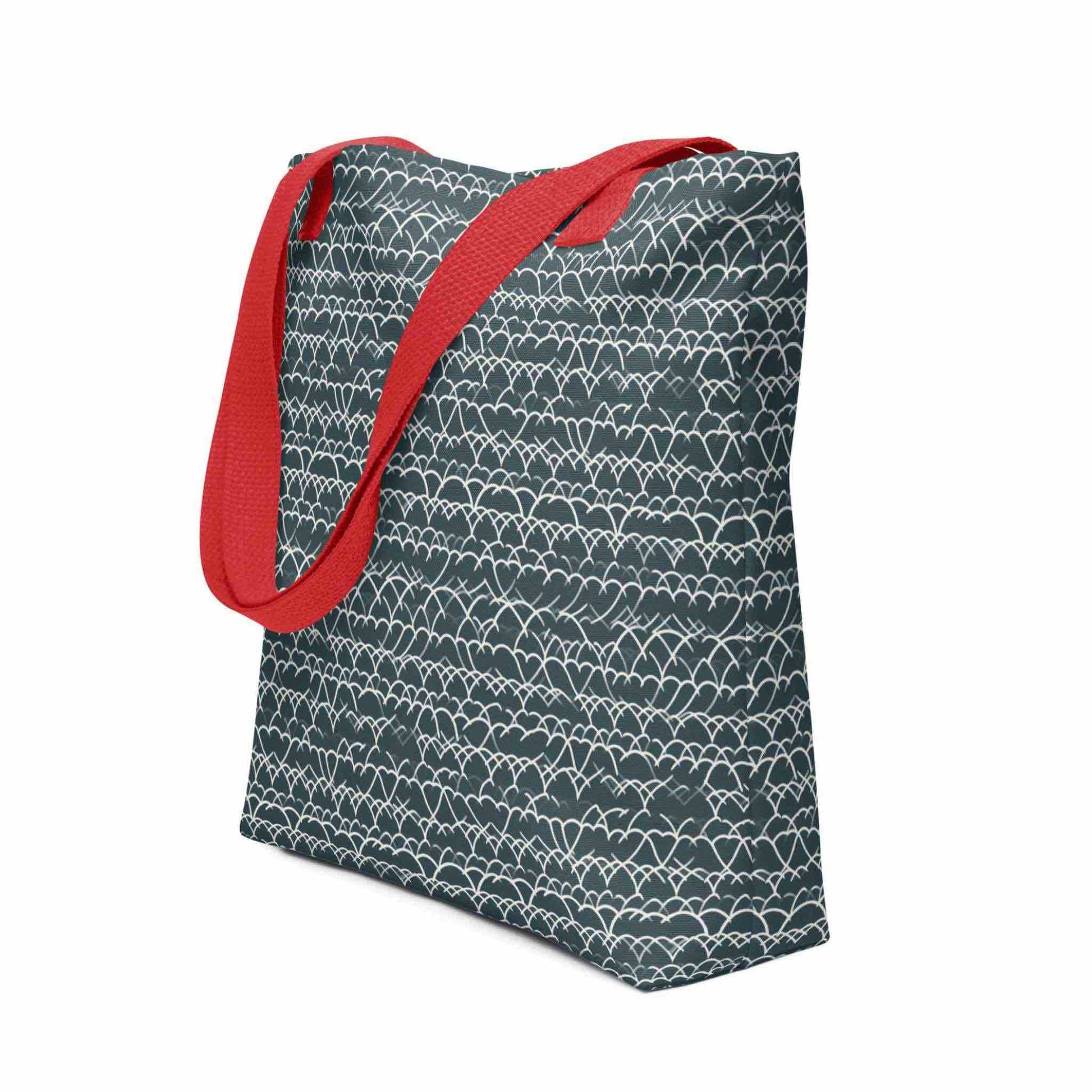 Side view of a 15x15 inch tote bag with red handles, which features a white geometric lace design that dances across a blue background. White background.