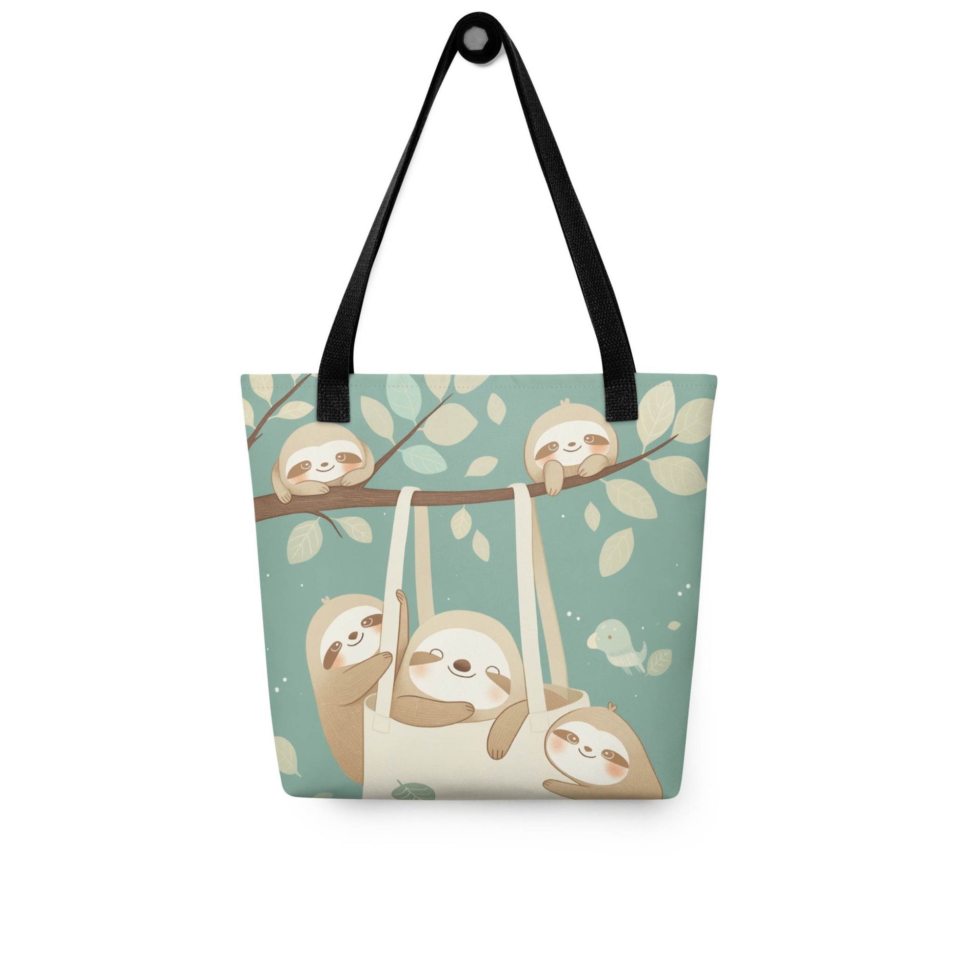 The cutest sloth tote bag you'll ever carry! This charming, sophisticated design captures the tranquility of the forest, with black shoulder handles, hanging on a wall. White background.