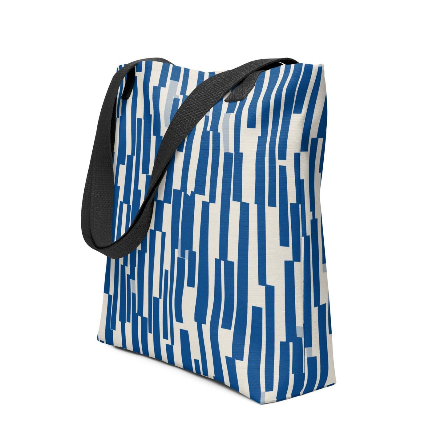 The tote bag blue, where rhythm meets charm. This abstract design features a chaotic yet charming cascade of navy shapes, resembling musical staccato notes played against a soft cream backdrop. Side view. White background.
