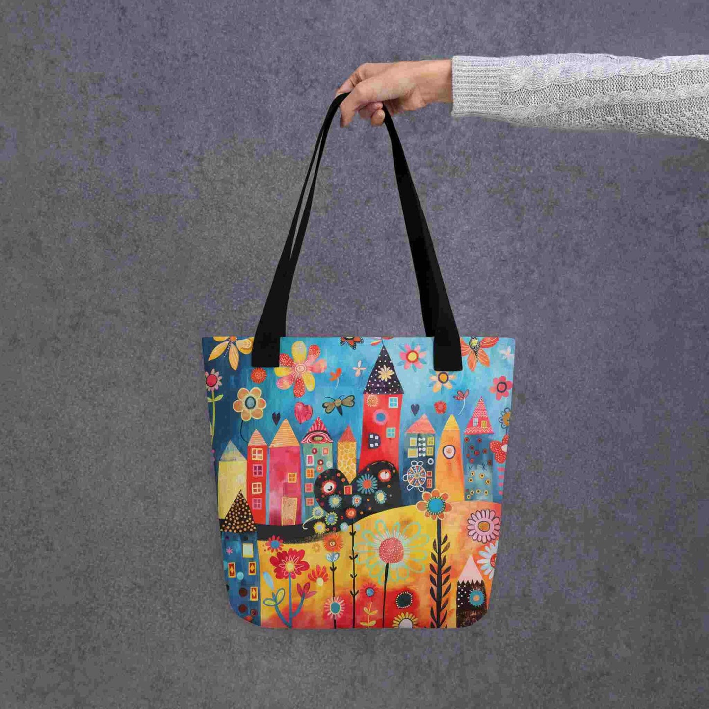 A ophisticated whimsical tote bag which brings vibrant folk art houses and flowers to life. Black handle. 15x15 inch. Grey background.