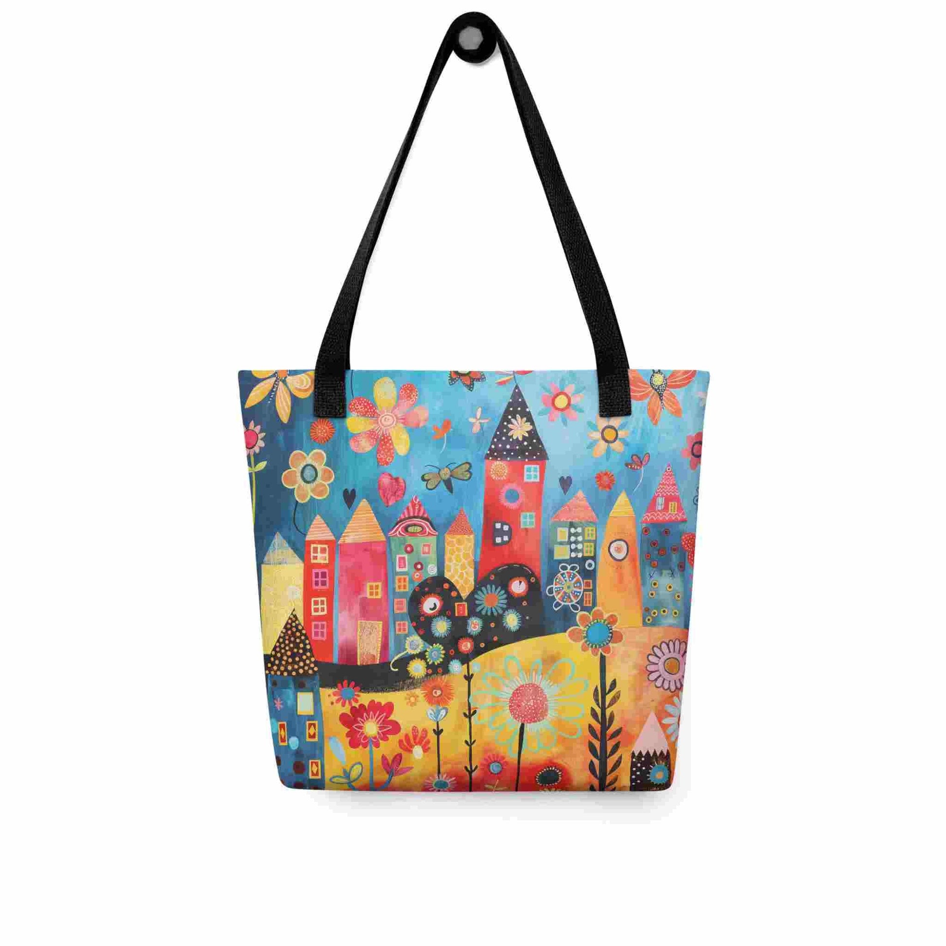 A ophisticated whimsical tote bag which brings vibrant folk art houses and flowers to life, with black handle, hanging on a wall. 15x15 inch. White background.