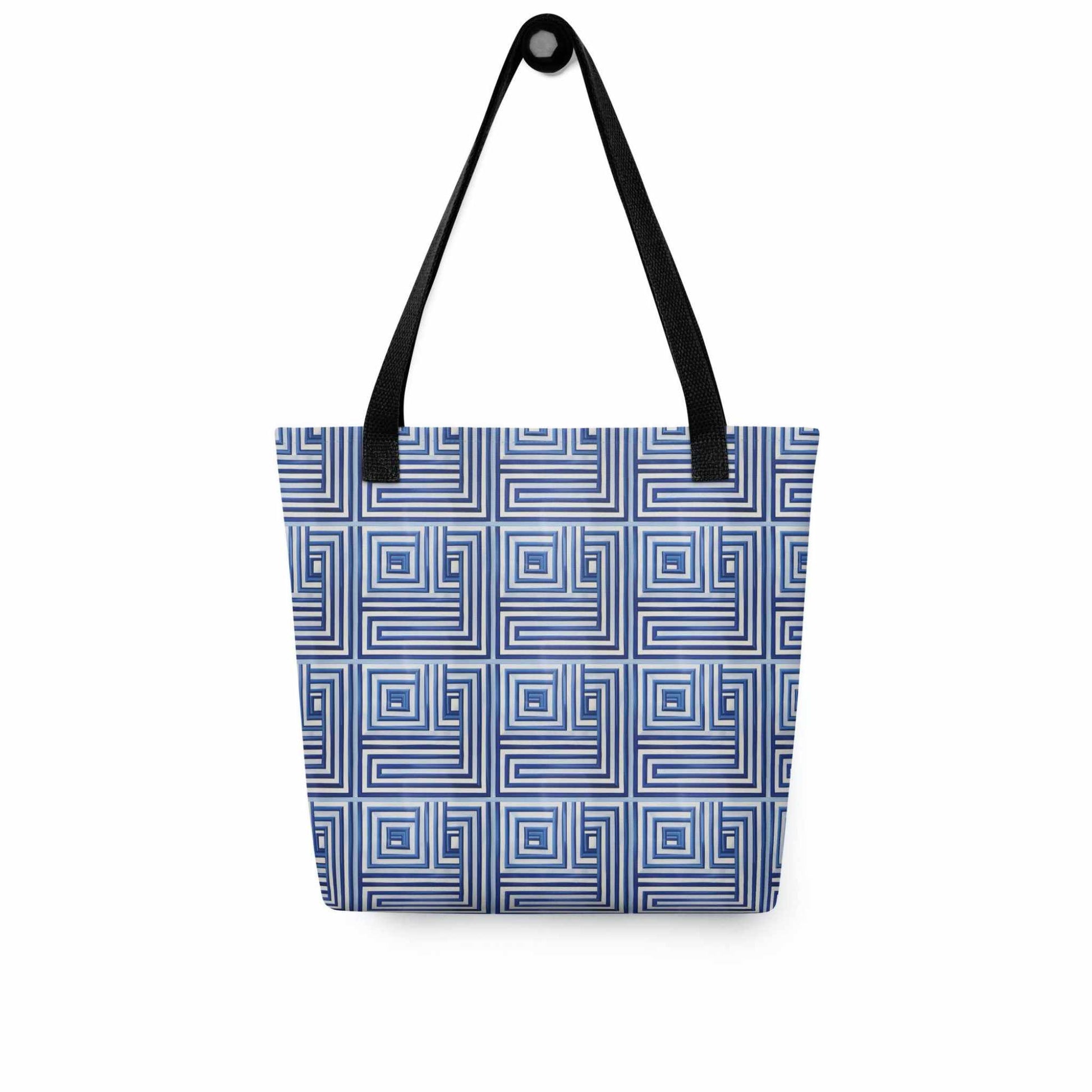 Blue op art tote with black handles, which features a blue op art illusion, hanging on a white wall.